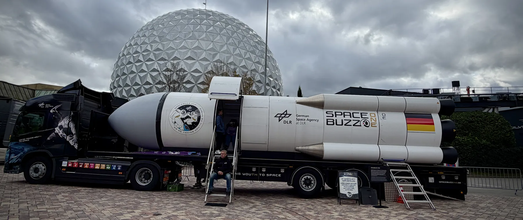 Die Rakete SPACEBUZZ ONE der Deutschen Raumfahrtagentur auf einem Lkw vor der großen Kugel des Europa-Park.